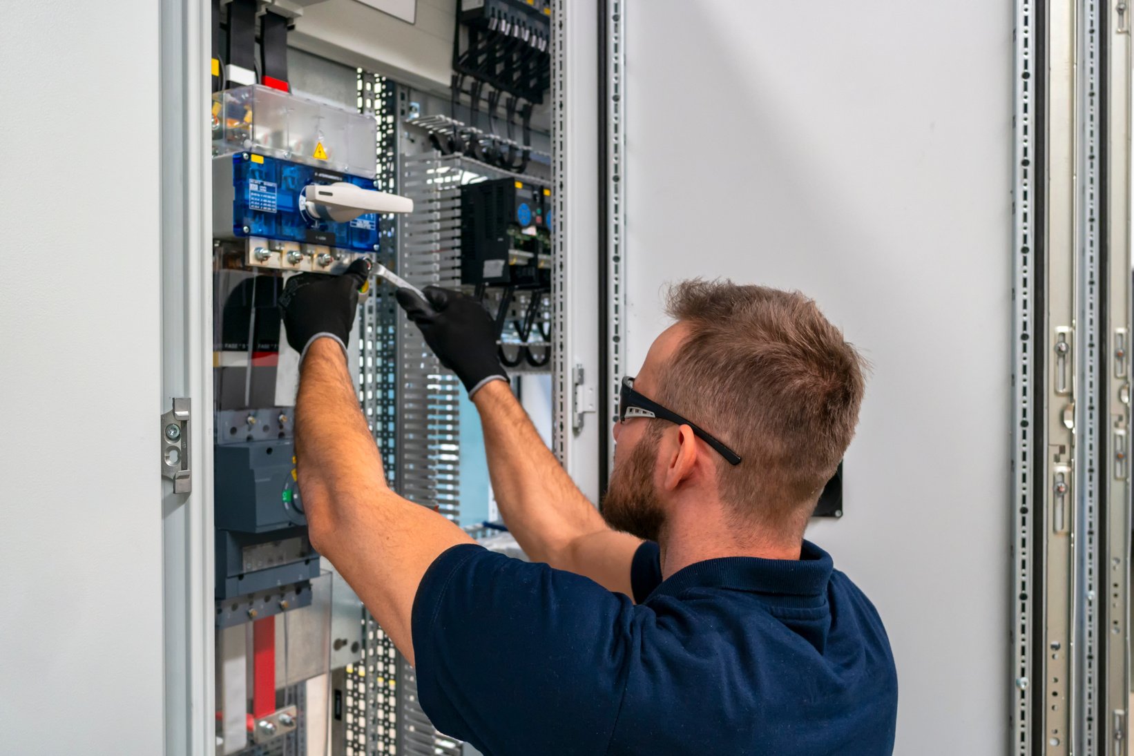 Electrician working at electric panel